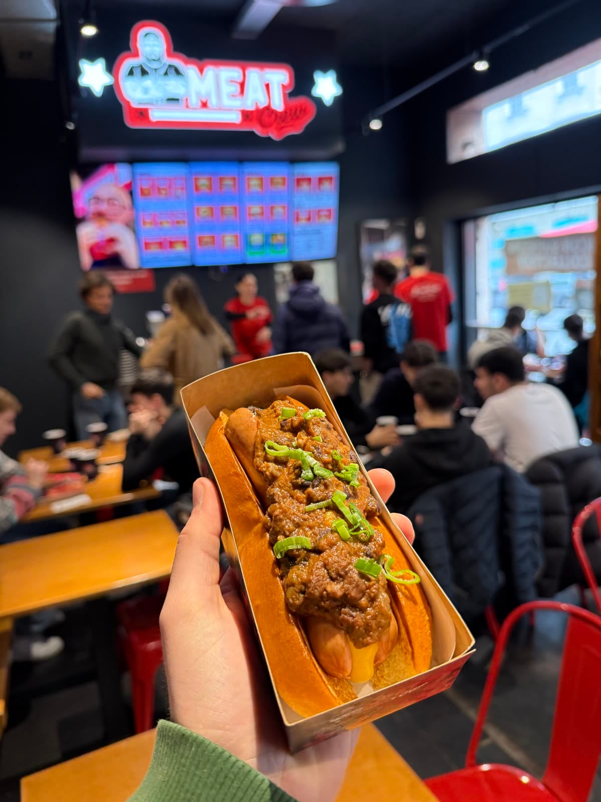 A Meat Crew chili dog held up in the dining room of the Viale Bligny store in Milan